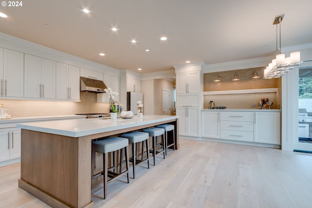 kitchen featuring a large island, backsplash, and white cabinetry