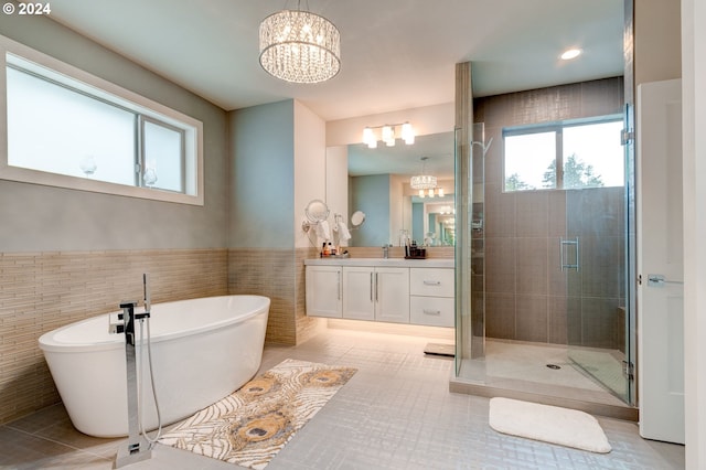 bathroom featuring separate shower and tub, tile walls, vanity, a notable chandelier, and tile patterned flooring