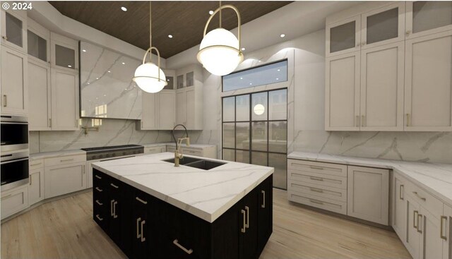 kitchen featuring backsplash, decorative light fixtures, sink, stainless steel double oven, and light wood-type flooring