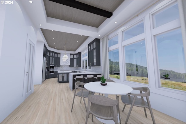 dining space with light hardwood / wood-style floors and a raised ceiling