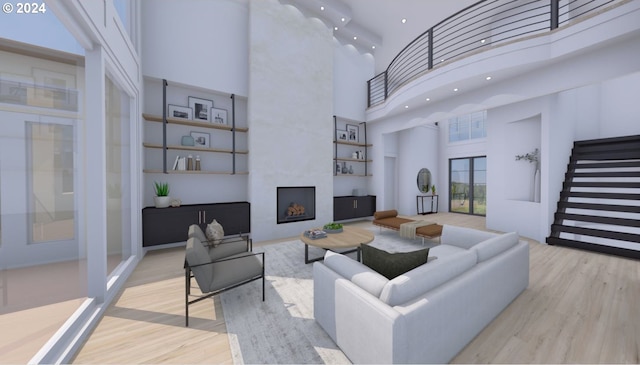 living room featuring a towering ceiling, a fireplace, and light hardwood / wood-style flooring