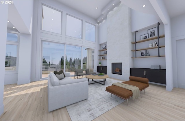 living room with a fireplace, beamed ceiling, light wood-type flooring, and a high ceiling