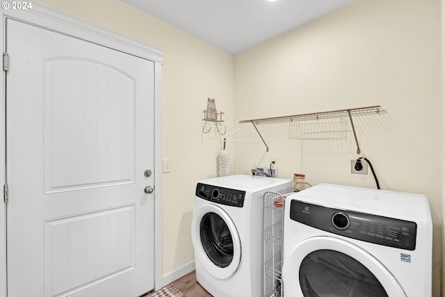 clothes washing area with wood-type flooring and washing machine and clothes dryer