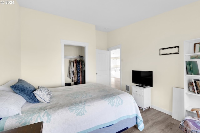 bedroom with hardwood / wood-style floors and a closet