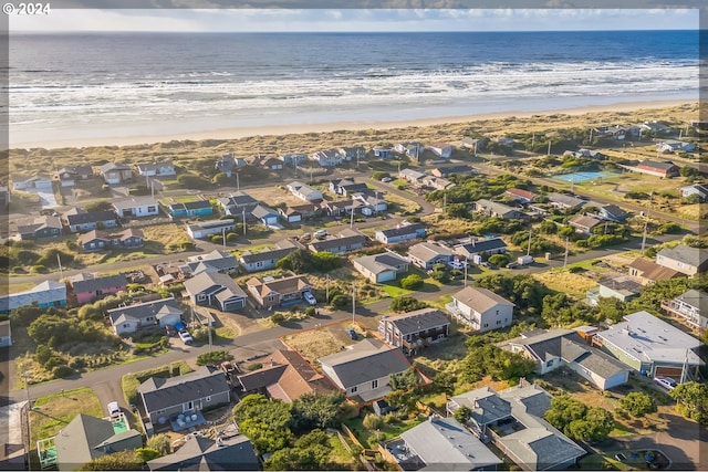 bird's eye view featuring a water view and a beach view