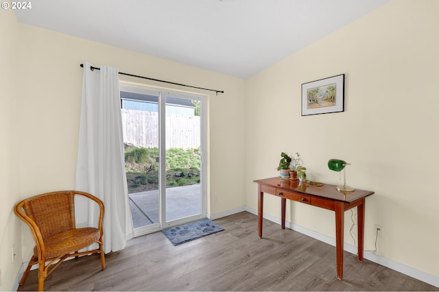 doorway with light hardwood / wood-style flooring and vaulted ceiling