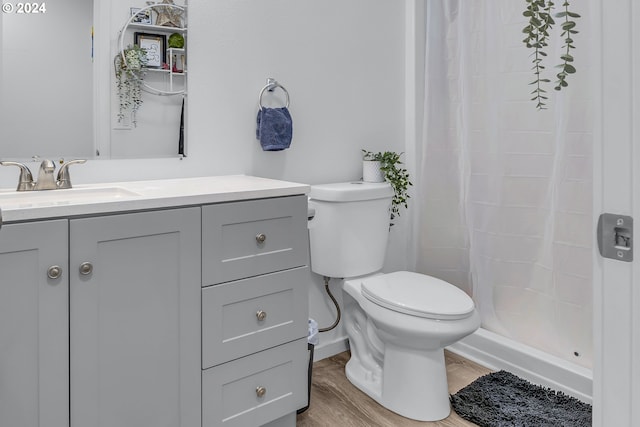 bathroom featuring a shower with shower curtain, vanity, hardwood / wood-style flooring, and toilet