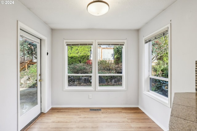 interior space with light wood-type flooring and a textured ceiling