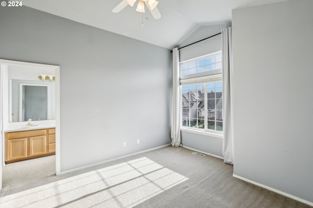 carpeted spare room featuring ceiling fan, sink, and lofted ceiling