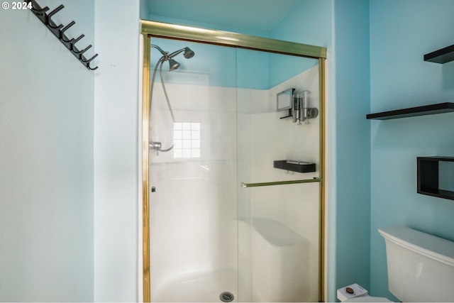 bathroom featuring toilet and an enclosed shower