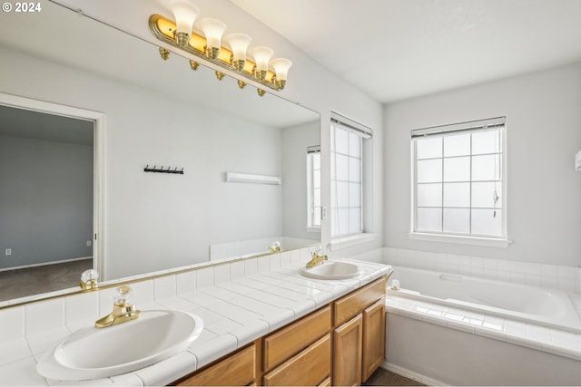 bathroom featuring vanity and a relaxing tiled tub