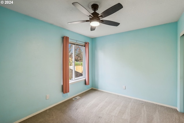 carpeted spare room featuring ceiling fan