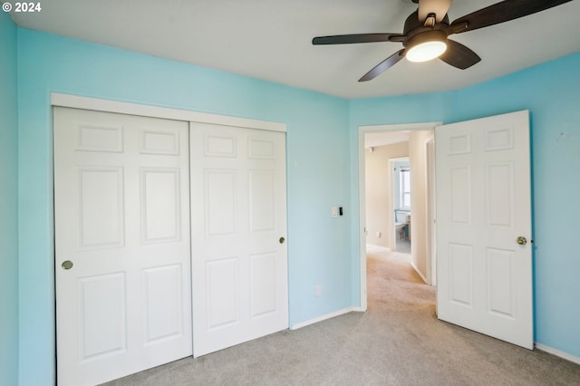 unfurnished bedroom with ceiling fan, light carpet, and a closet