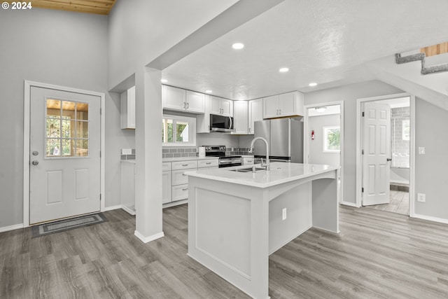 kitchen featuring light hardwood / wood-style floors, appliances with stainless steel finishes, white cabinetry, and sink