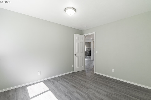 unfurnished room with dark wood-type flooring