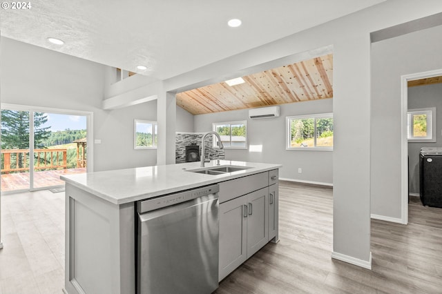 kitchen with a kitchen island with sink, a wall unit AC, sink, gray cabinets, and dishwasher