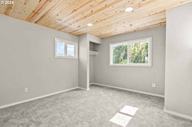 spare room with carpet floors, plenty of natural light, and wood ceiling