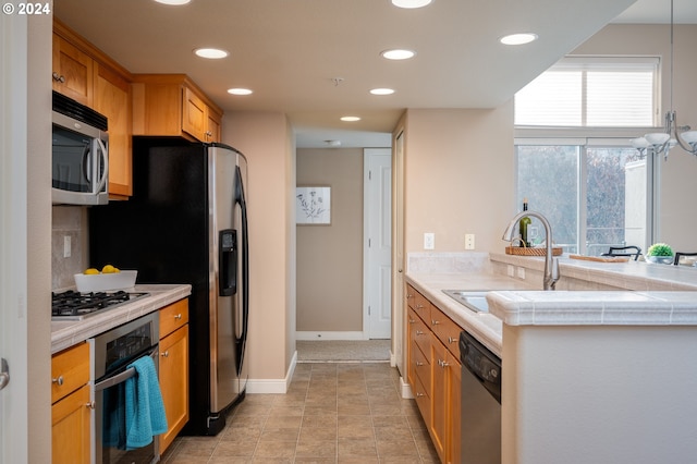 kitchen with appliances with stainless steel finishes, sink, and light tile patterned floors