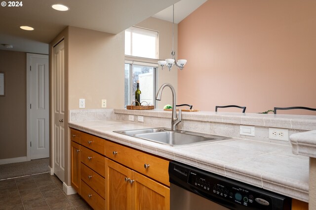 kitchen with tile countertops, backsplash, sink, light hardwood / wood-style flooring, and stainless steel appliances