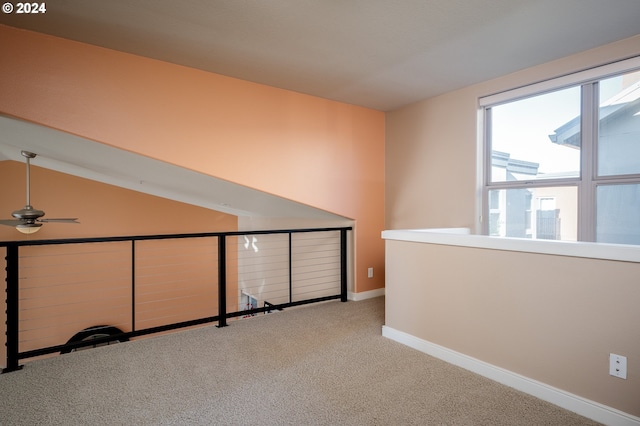 carpeted empty room featuring ceiling fan and vaulted ceiling