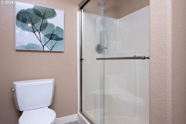 bathroom with toilet and an enclosed shower