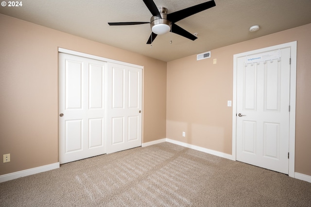 unfurnished bedroom featuring carpet flooring, a textured ceiling, ceiling fan, and a closet