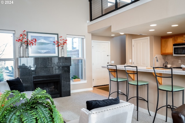 living room featuring a tiled fireplace and a high ceiling