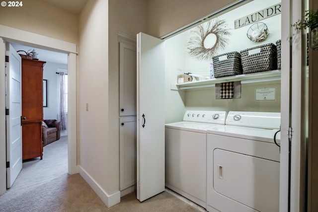 clothes washing area with washer and clothes dryer and light colored carpet