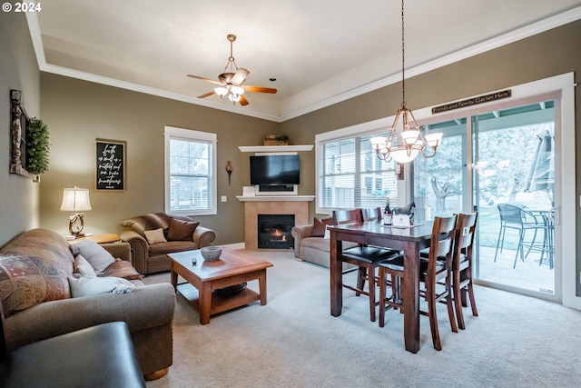 living room with crown molding, a fireplace, light colored carpet, and ceiling fan with notable chandelier