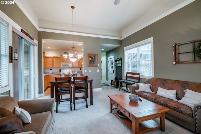 living room featuring light carpet, an inviting chandelier, and crown molding