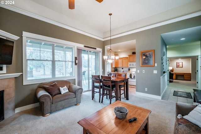 carpeted living room with a fireplace and ceiling fan with notable chandelier