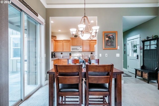 kitchen with an inviting chandelier, crown molding, light colored carpet, decorative light fixtures, and light brown cabinetry