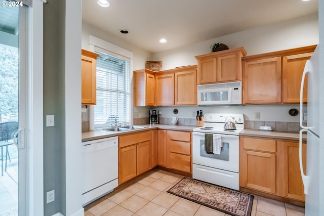 kitchen featuring sink, light tile patterned floors, white appliances, and light brown cabinets