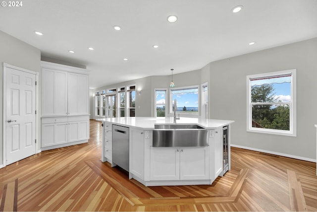 kitchen with recessed lighting, a sink, white cabinets, light countertops, and stainless steel dishwasher