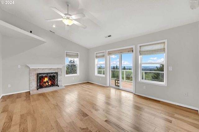 unfurnished living room featuring light wood-type flooring, baseboards, visible vents, and a stone fireplace