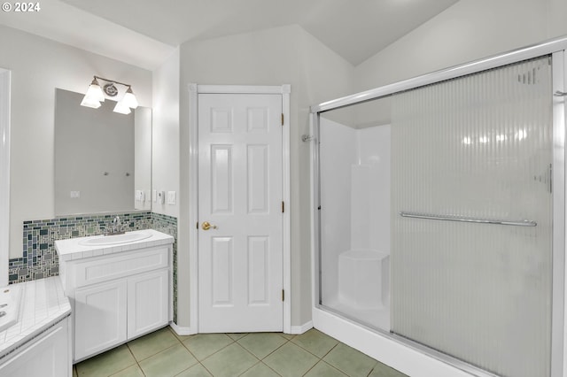 bathroom with a stall shower, tile patterned flooring, lofted ceiling, and vanity