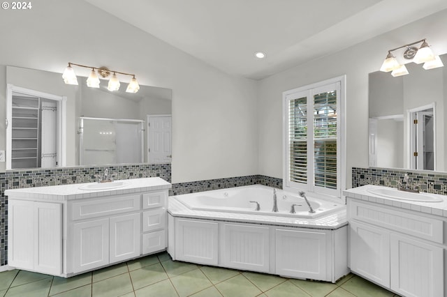 full bathroom with a jetted tub, a stall shower, a sink, and tile patterned floors