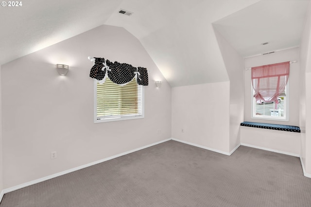 bonus room with carpet floors, visible vents, baseboards, vaulted ceiling, and plenty of natural light