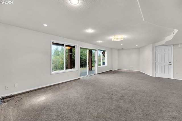 spare room with a textured ceiling, recessed lighting, carpet, and baseboards