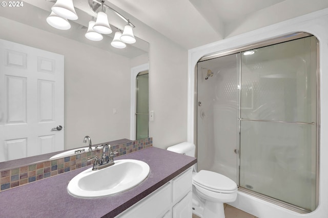 bathroom with vanity, a shower stall, and toilet