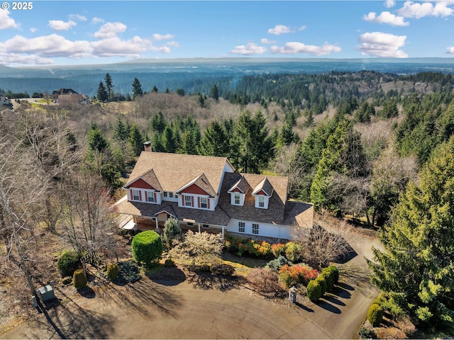 birds eye view of property featuring a forest view