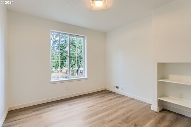 spare room with light hardwood / wood-style flooring