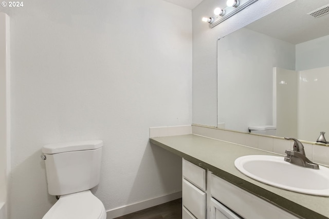 bathroom featuring hardwood / wood-style floors, vanity, and toilet