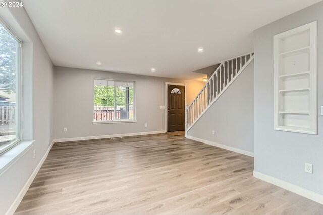 interior space with light wood-type flooring and built in shelves