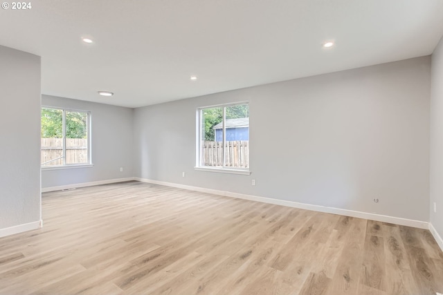 empty room featuring light hardwood / wood-style flooring and a wealth of natural light