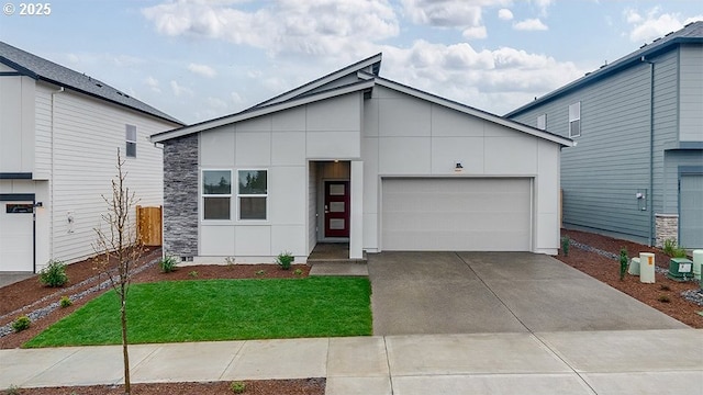 view of front of property featuring stone siding, driveway, an attached garage, and a front yard