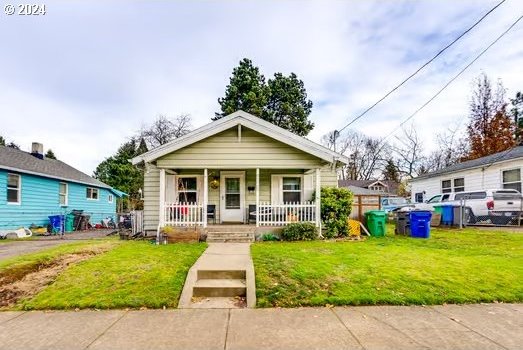 bungalow-style home with covered porch and a front lawn