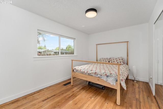 bedroom featuring wood-type flooring and a textured ceiling