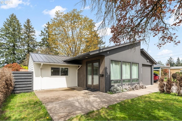 back of property with a lawn and a garage