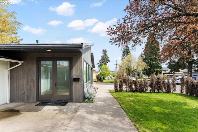 property entrance featuring a yard and french doors